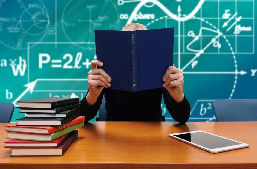 Estudantes estudam juntos diante de livros e anotações em contexto acadêmico.